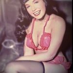 A happy Bettie Page in red